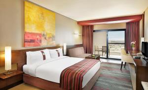 索瓦马死海假日酒店的酒店客房设有一张大床和一台电视。