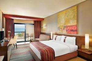 索瓦马死海假日酒店的酒店客房设有一张大床和一张书桌。