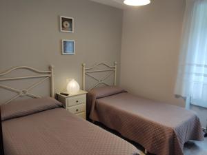 里瓦德奥OS MUIÑOS的一间卧室配有两张床和一张带台灯的桌子