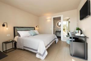 努马纳bed&breakfast Filomare的卧室配有白色的床和电视。