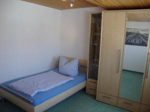 DombühlHaus Reif的一间带一张床和一个衣柜的小卧室