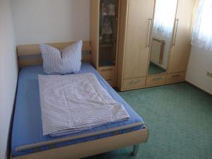 DombühlHaus Reif的一间卧室配有带枕头和橱柜的床