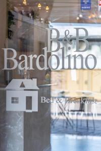 CalmasinoAffittacamere Bardolino的窗户上的一个理发店标志的反射