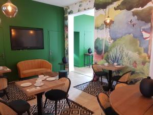 贝尔奈Le Clos des Lodges的一间带桌椅和绿色墙壁的餐厅