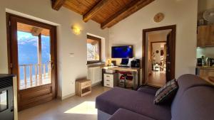 Villar PelliceIndependent chalet with breathtaking view的客厅配有紫色沙发和书桌