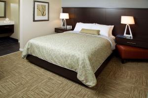 圣何塞Sonesta ES Suites San Jose - Airport的酒店客房设有一张大床和两盏灯。