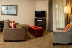 圣何塞Sonesta ES Suites San Jose - Airport的客厅配有2把椅子和平面电视