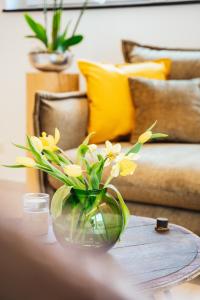 贝尔恩卡斯特尔-库斯Weinrebe的一张桌子上装有黄色花朵的玻璃花瓶
