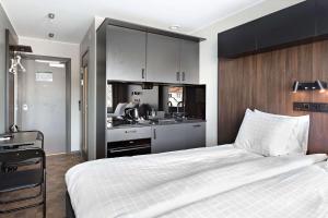 斯德哥尔摩Sure Hotel Studio by Best Western Bromma的一间带白色大床的卧室和一间厨房