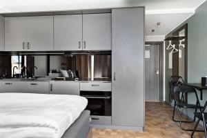 斯德哥尔摩Sure Hotel Studio by Best Western Bromma的一间厨房,配有白色的橱柜和一张位于客房内的床