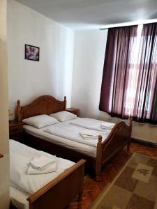 DumbrăveniHOTEL MARION的带窗户的客房内设有两张单人床。