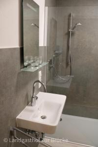 SenhalsAparthotel Layblick的浴室配有盥洗盆和带镜子的淋浴