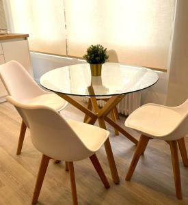 阿兰达德杜洛Apartamentos Aranda - VUT- La Cepa I - II的一张玻璃桌,上面有四把白色椅子和盆栽植物