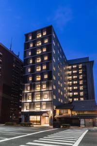 京都Sotetsu Fresa Inn Kyoto-Kiyomizu Gojo的一座高大的黑色建筑,有许多窗户