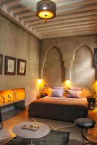 马拉喀什Riad Heva的一间卧室配有一张大床和一张桌子