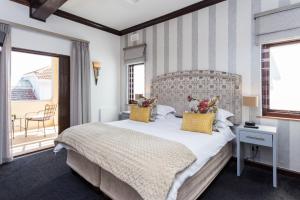 开普敦马顿斯宾馆的一间卧室设有一张带条纹墙的大床