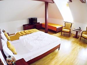 TopoľčiankyHradná stráž Hotel&Apartments s privátnym wellness的一间卧室配有一张大床和两把椅子