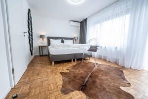 腓特烈港City Apartments FN L 6 KLIMATISIERT mit Balkon - Deluxe Doppelzimmer的一间卧室配有一张床,铺有木地板