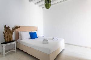 帕诺尔莫斯米科诺斯Villa ANASA private Pool & Jacuzzi 8pax at Panormos的白色卧室配有蓝色枕头的床