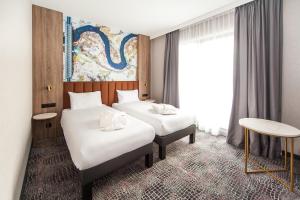 比亚韦斯托克Mercure Bialystok的酒店客房设有两张床和窗户。