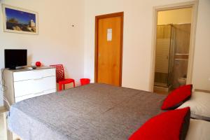圣夫拉维亚西西里奥住宿加早餐旅馆的一间卧室配有一张带红色枕头的床和电视。
