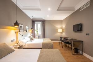 马德里库特佐梅迭姆酒店的酒店客房配有两张床和一张书桌
