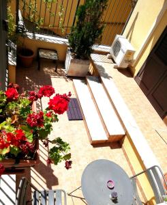 圣夫拉维亚西西里奥住宿加早餐旅馆的一个带红色鲜花和桌椅的庭院