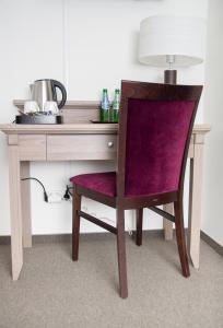 波兹南WILla Medica的一张带紫色椅子的桌子和一张带台灯的桌子