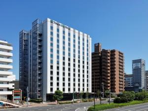 东京Tmark City Hotel Tokyo Omori - Vacation STAY 26381v的城市街道上一座高大的白色建筑,有建筑
