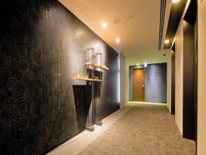 东京Tmark City Hotel Tokyo Omori - Vacation STAY 26381v的走廊上设有黑墙,上面有架子