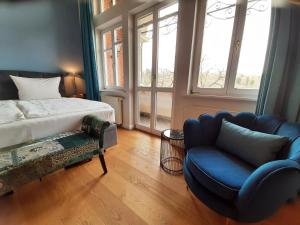 布兰肯堡维多利亚·路易丝别墅酒店的一间卧室配有一张床、一张沙发和一把椅子