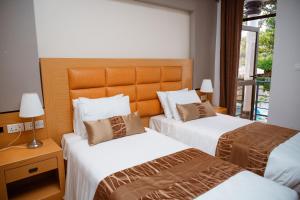 基加利Ndaru Luxury suites的酒店客房设有两张床和窗户。