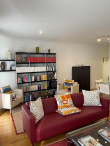 巴塞罗那倩宁公寓的客厅配有红色沙发和书架