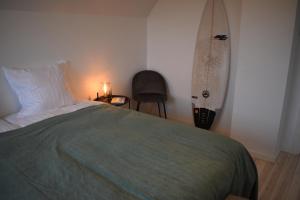 克利特默勒Viking Surf House的卧室配有一张床,墙上设有冲浪板