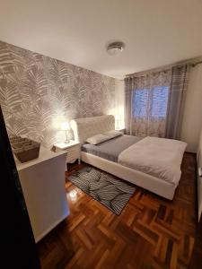 索科矿泉村Lux Apartman Ristić 1的一间卧室配有一张床、一张桌子和一个窗户。