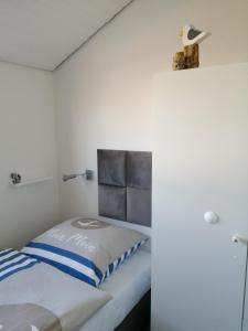 库克斯港Bude im Windrosenweg的一间小卧室,配有一张床和白色的墙壁