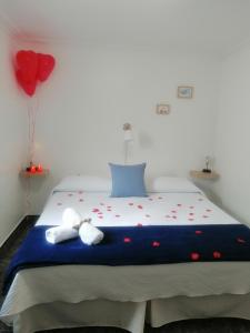 洛斯克里斯蒂亚诺斯Pensión Playa的一间卧室配有一张带两条毛巾和气球的床。