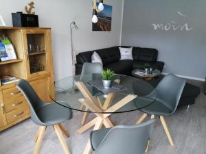 库克斯港Bude im Windrosenweg的客厅配有玻璃桌和椅子