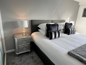 格拉斯哥Modern & Spacious 2 bed Merchant City Apart-High St的一间卧室配有一张带黑白枕头的床