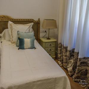 阿尔莫纳斯特尔拉雷亚尔HOTEL LUZ ALMONASTER的一间卧室配有带白色床单和蓝色枕头的床。