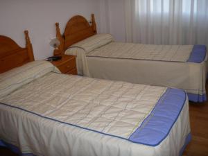 Vega de Espinareda奎斯塔旅馆的一间带两张床和梳妆台的卧室