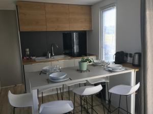 Saint-Léger-sur-DheuneLe Lodge Premium的厨房配有带白色椅子的桌子和水槽