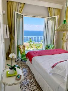 卡普里卡萨玛塔卡普里酒店的一间卧室配有一张床,享有海景