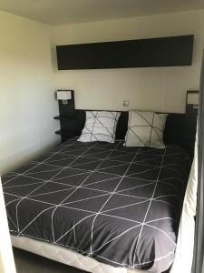 Saint-Léger-sur-DheuneLes Lodges的一间卧室配有一张带黑白色棉被的床
