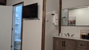 斯阔谷Clingan's Junction Cottage #4的一间带水槽的浴室和墙上的电视