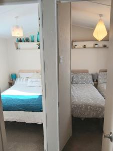 KentGriffiths, Seaview Caravan Park, Whitstable的一间卧室配有两张床和镜子