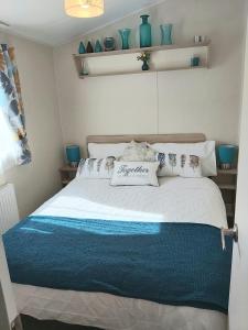 KentGriffiths, Seaview Caravan Park, Whitstable的一间卧室配有一张大床和枕头