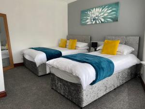 斯旺西Cosy 2 Bed Flat 1 in Swansea - Home away from Home的配有两张黄色和蓝色枕头的床铺