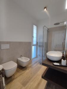 巴多利诺La Rondinella Apartments的浴室配有2个白色水槽和1个浴缸。