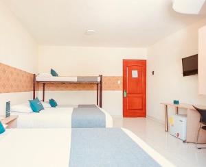 巴兰基亚Hotel Rivera Del Mar的一间设有两张床和红色门的房间
